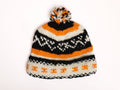 Knitted hat with orange, black, and white pattern on a white background