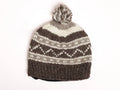 Knitted beanie with grey pattern and a pom-pom on a white background
