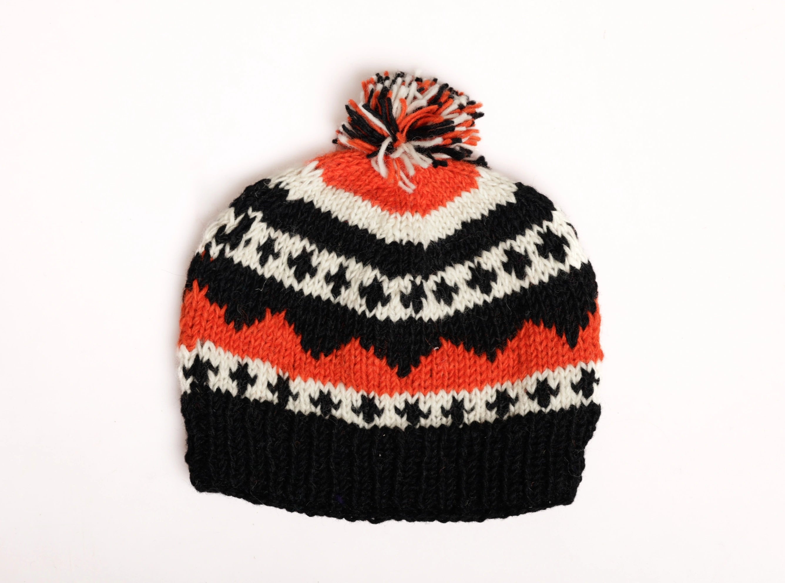 Black and orange knitted hat with a pom-pom on a white background