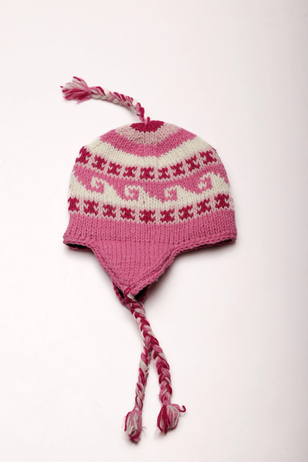 Pink and white knitted hat with pattern on a white background