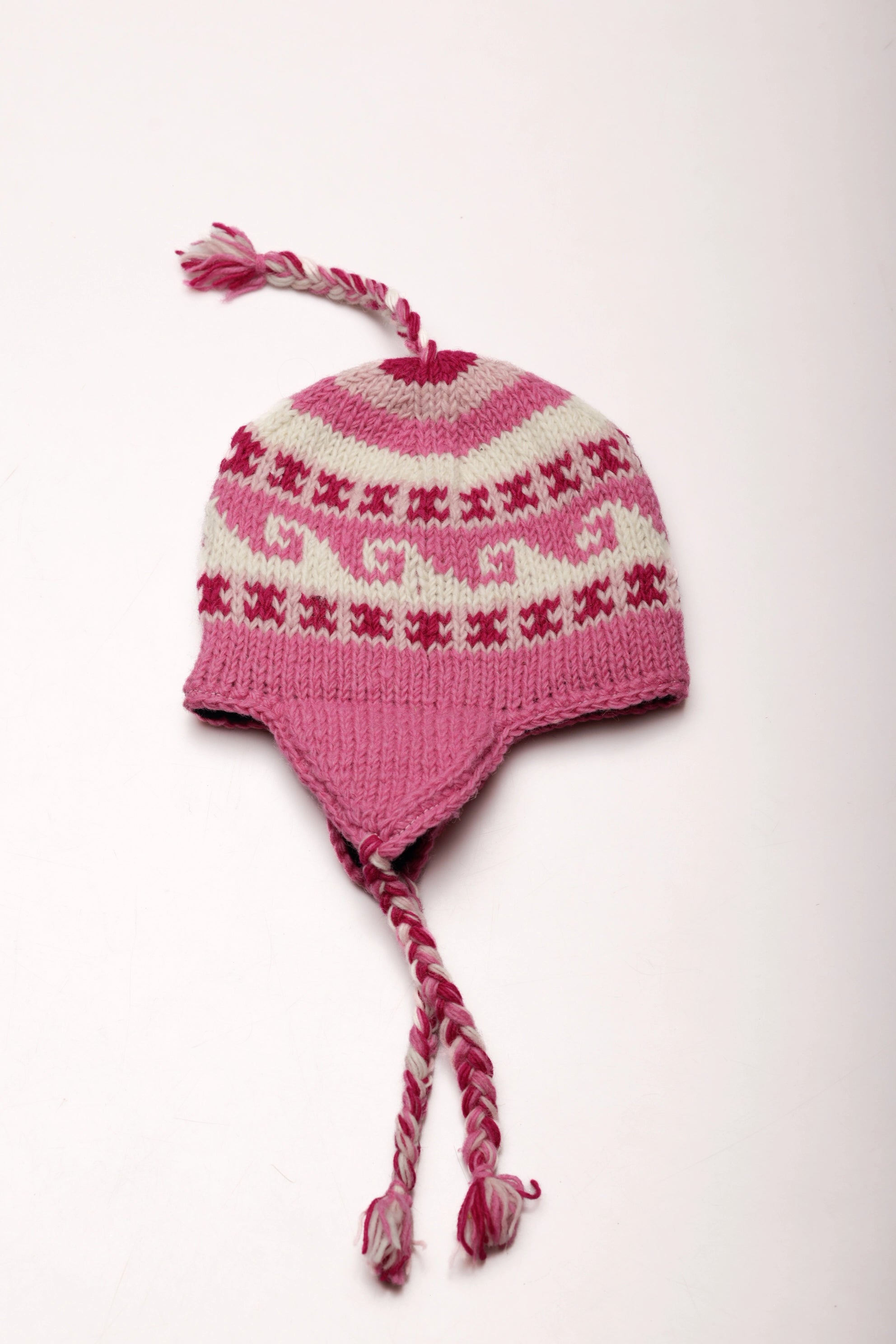 Pink and white knitted hat with pattern on a white background