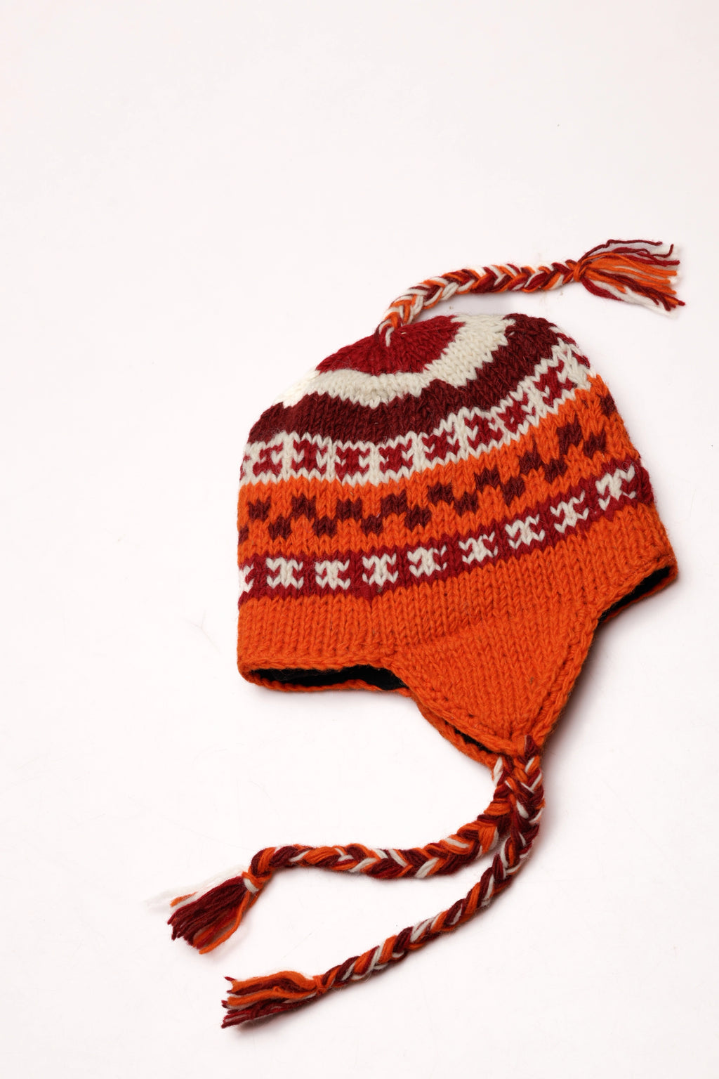 Knitted hat with orange, red pattern on a white background