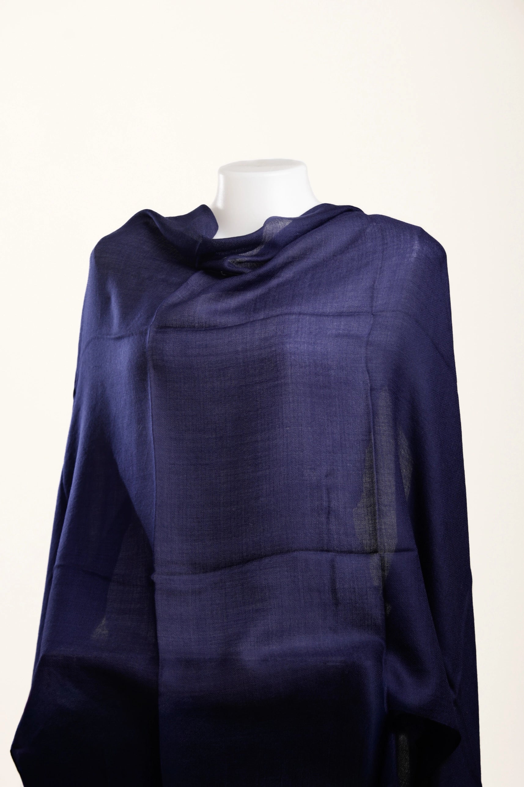 Navy blue shawl on a mannequin against a white background