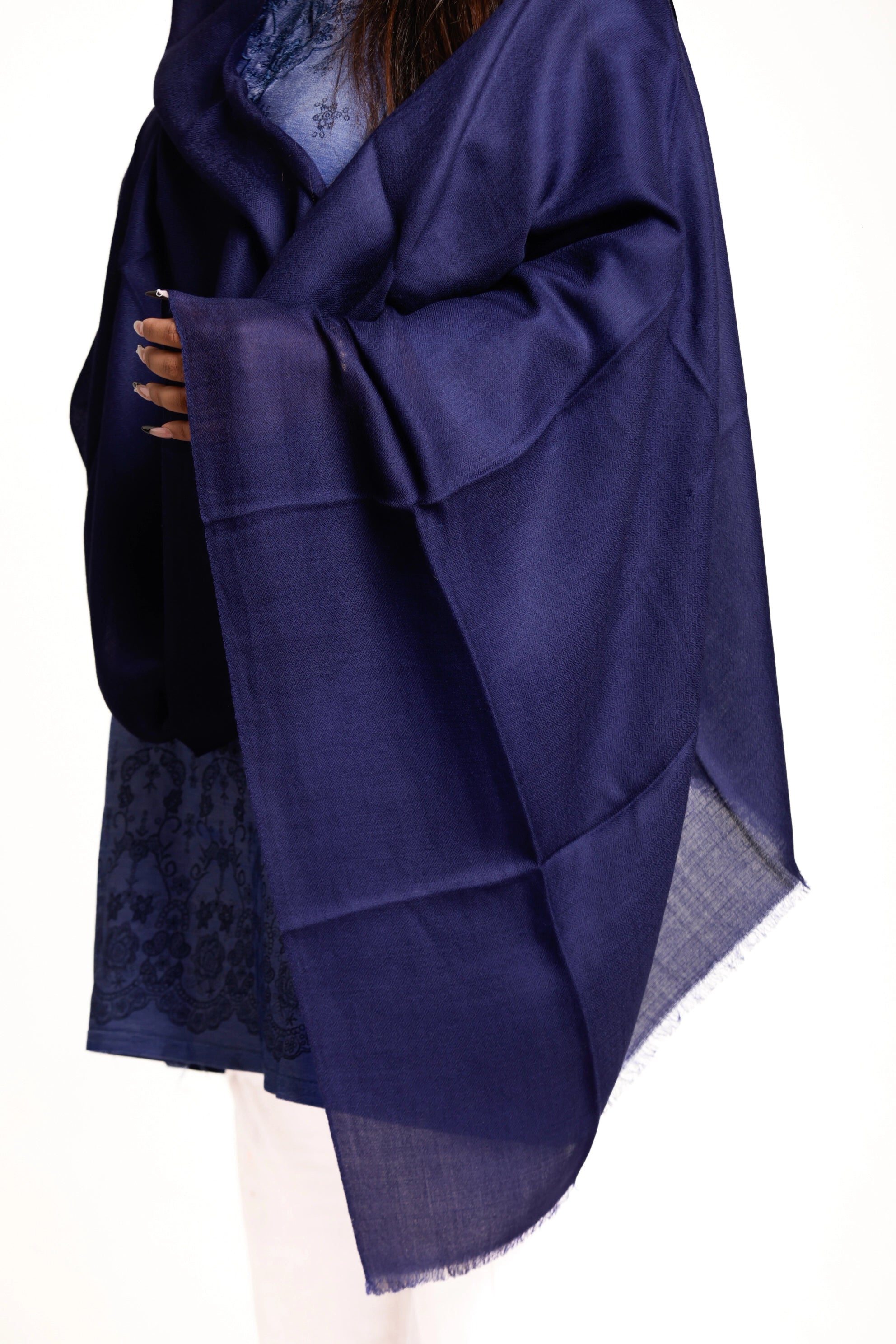Navy blue shawl with lace trim draped over a person on a white background