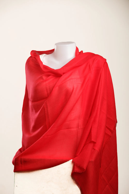Red scarf draped over a mannequin on a white background