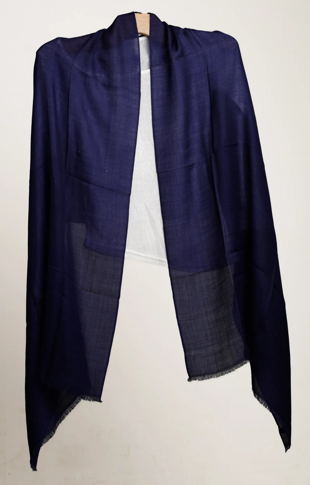 Navy blue shawl draped over a white background
